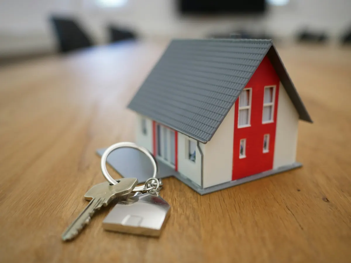 House keys resting on a wood floor inside a freshly prepared home
